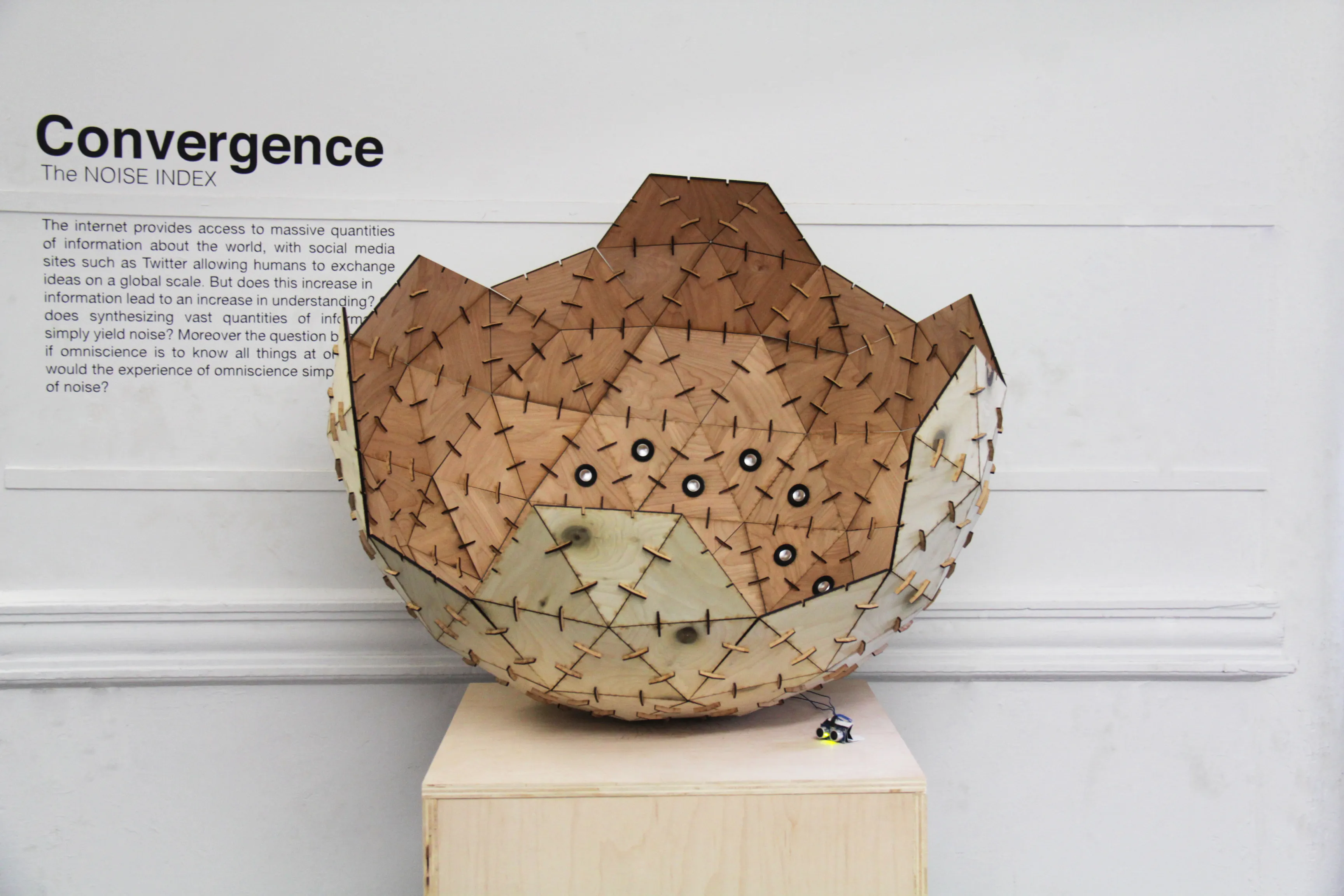 Three-quarter view with the sphere at right on its plinth and the full wall text legible at left.