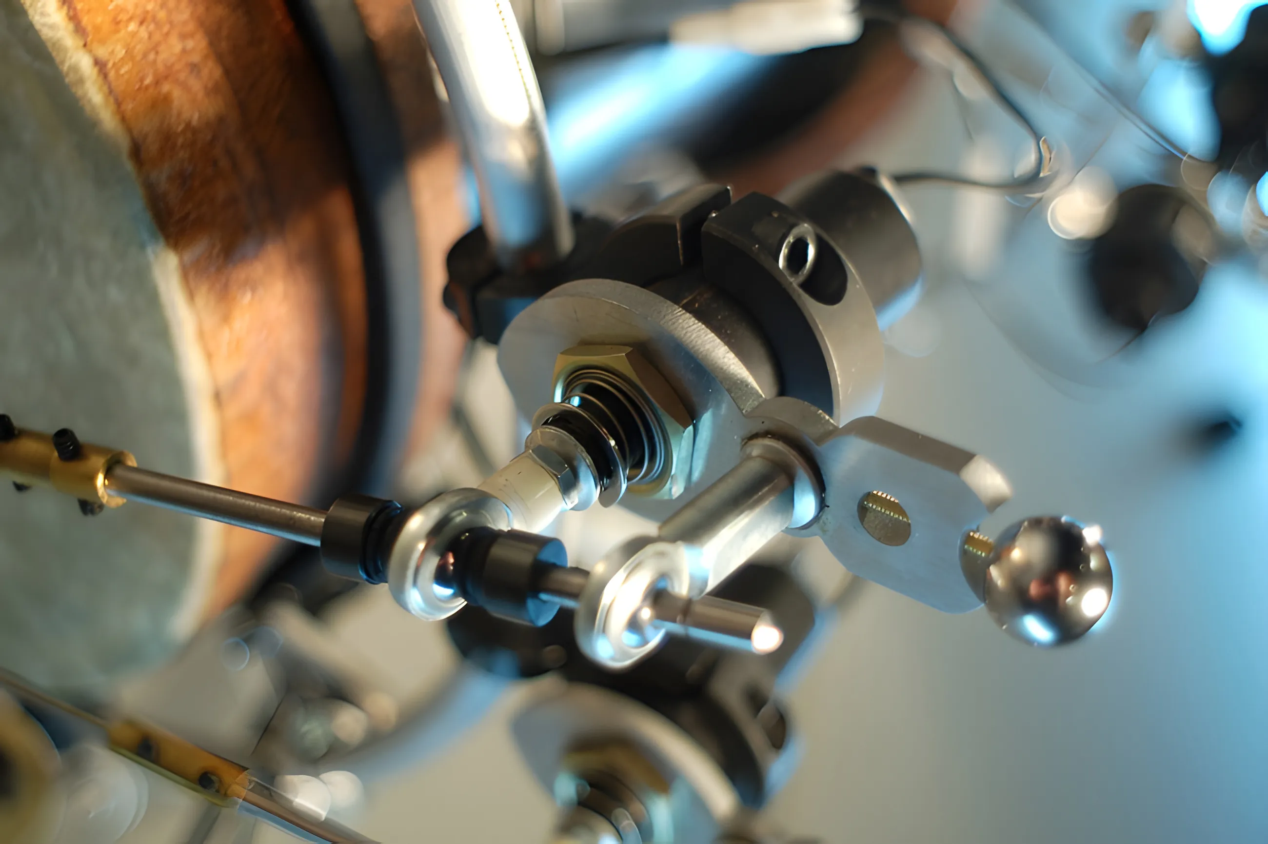 Close-up of a machined solenoid beater clamped at a drum rim, chrome ball striker poised against the shell.